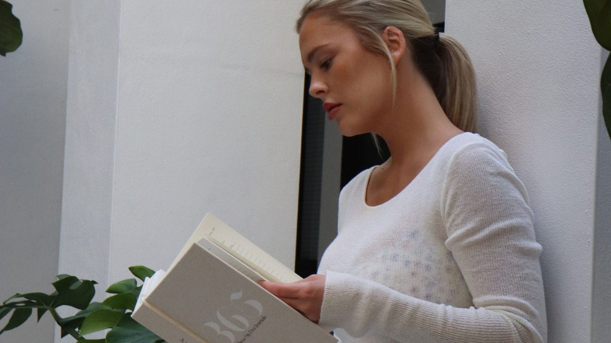 Woman in white dress looking at 365 Journal