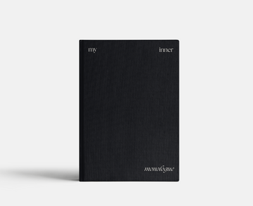 Black notebook with 'my inner monologue' text on a light gray background