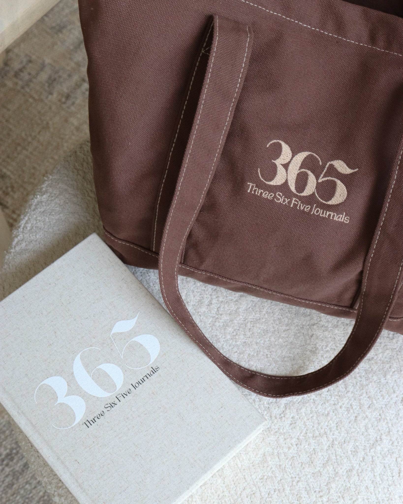 Brown tote bag with '365' branding on a textured surface